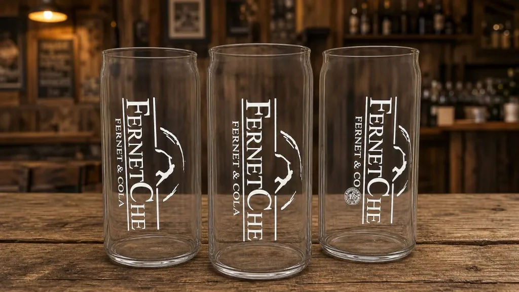 Três copos Fernetchê de vidro sobre balcão de bar